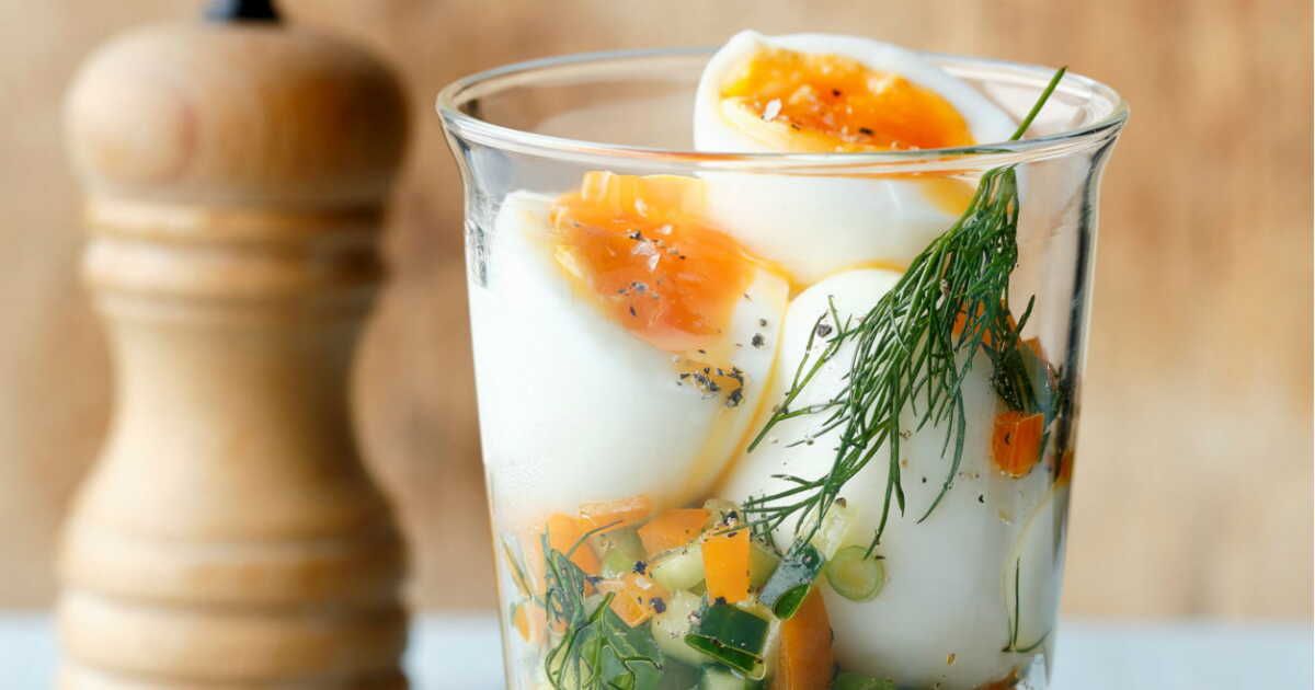 Des verrines d'œufs mollets sur un lit coloré de tartare de légumes